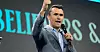 Charlie Kirk er en høyreradikal aktivist i USA. 31-åringen har blitt en av de største stjernene i Donald Trumps MAGA-bevegelse. Bildet av Kirk ble brukt under konferansen for å vise fascismens forvandling fra militærstøvler til skreddesydde dresser.