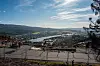 Utsikt over Krokstadelva med vann, bebyggelse og åser fra et inngjerdet uteområde.
